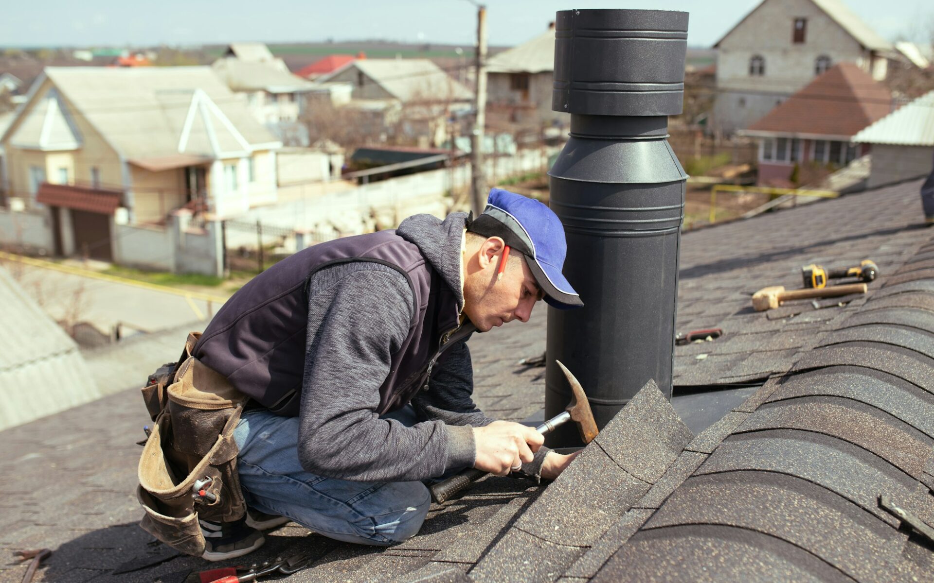 a professional master (roofer) with hammer repairs the roof.